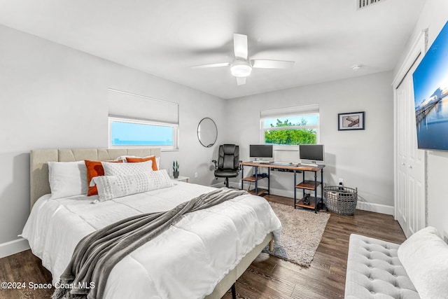 bedroom with a closet, dark hardwood / wood-style floors, and ceiling fan