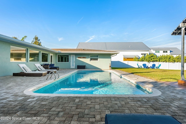 view of pool with a lawn and a patio