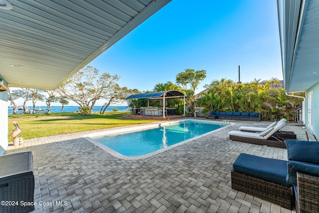 view of pool with an outdoor living space, a gazebo, a water view, a patio area, and a yard