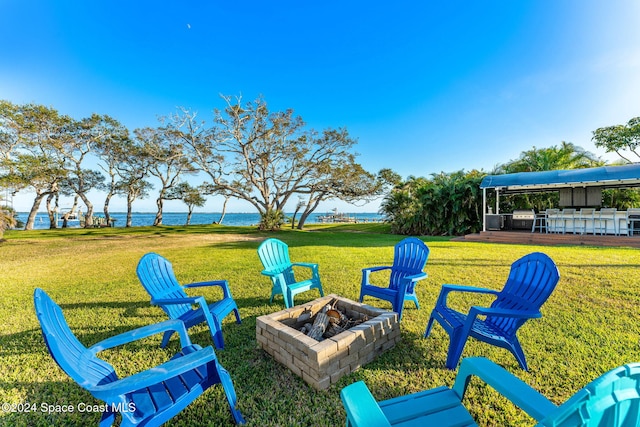 view of yard featuring a water view and an outdoor fire pit