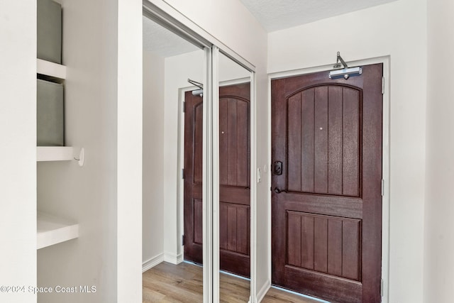 entryway featuring light hardwood / wood-style flooring and a textured ceiling