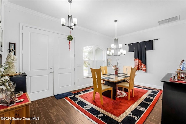 dining area with dark hardwood / wood-style floors, ornamental molding, and an inviting chandelier