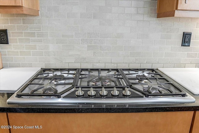 interior details with backsplash and stainless steel gas cooktop