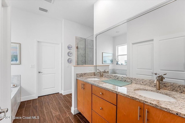 bathroom featuring hardwood / wood-style floors, vanity, and shower with separate bathtub