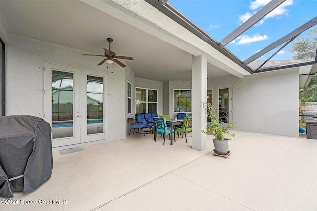 view of patio featuring french doors, grilling area, glass enclosure, and ceiling fan