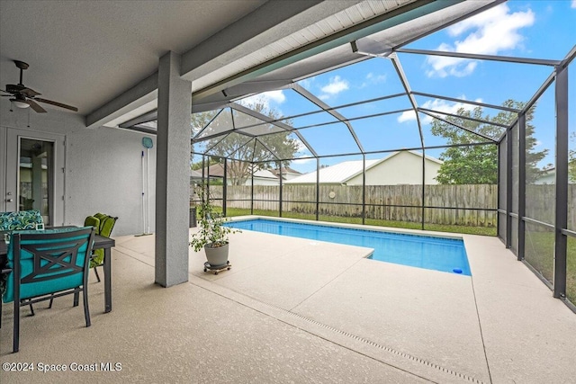 view of swimming pool featuring ceiling fan, a patio area, and a lanai