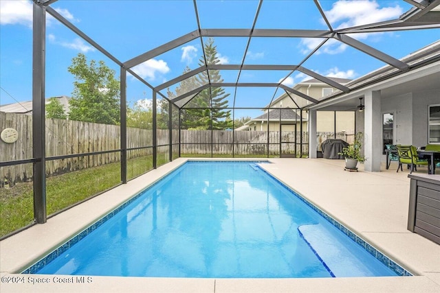 view of swimming pool featuring glass enclosure and a patio area