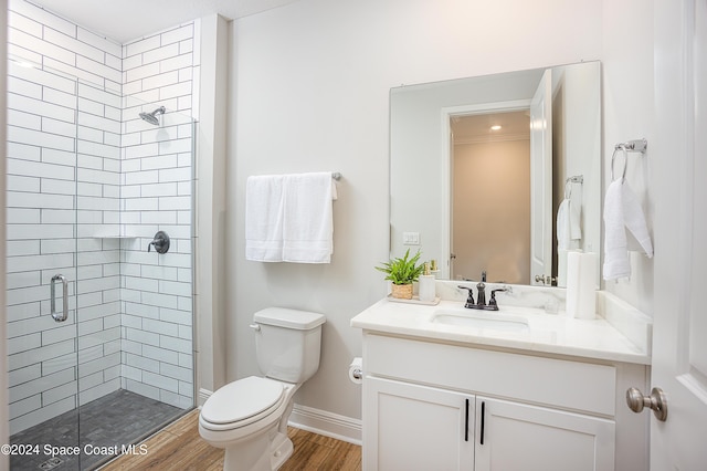 bathroom featuring vanity, hardwood / wood-style flooring, toilet, and a shower with shower door