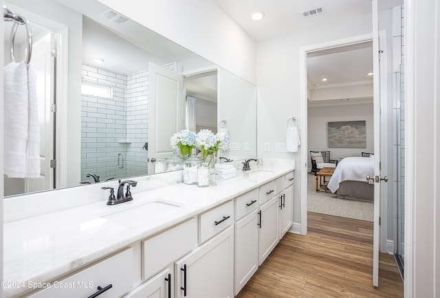 bathroom with wood-type flooring, vanity, and an enclosed shower