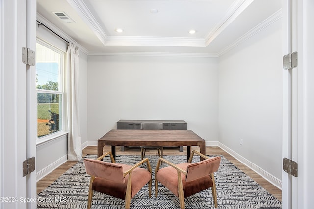 home office featuring wood-type flooring, a raised ceiling, and crown molding