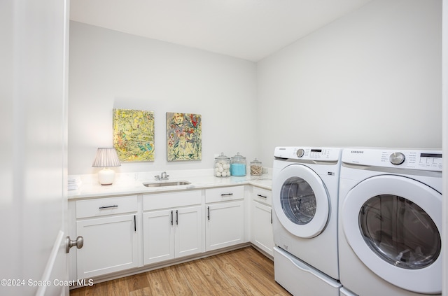 washroom featuring washer and dryer, light wood-type flooring, cabinets, and sink