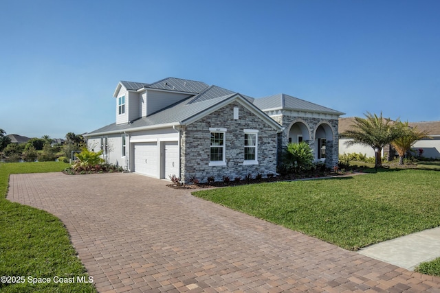 view of front facade with a front lawn, decorative driveway, stone siding, and metal roof