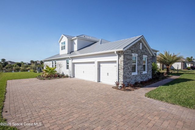 view of property exterior featuring decorative driveway, a lawn, and metal roof