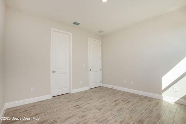 unfurnished room with visible vents, baseboards, and light wood-style floors