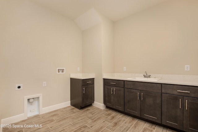 clothes washing area featuring hookup for a washing machine, wood finish floors, hookup for an electric dryer, and a sink