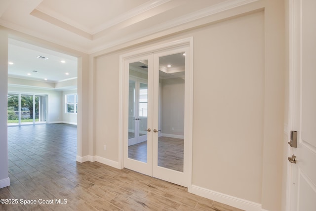 unfurnished room featuring light wood-style flooring, french doors, and crown molding