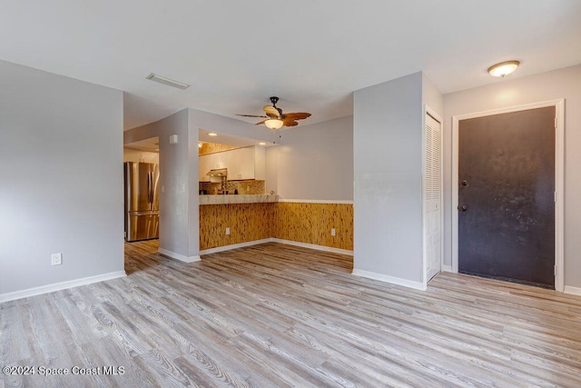 unfurnished living room featuring ceiling fan and light hardwood / wood-style flooring