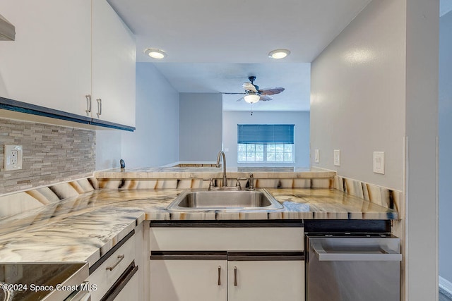 kitchen featuring decorative backsplash, ceiling fan, sink, stainless steel stove, and white cabinetry