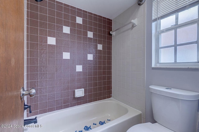 bathroom featuring tiled shower / bath combo and toilet