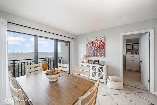 tiled dining space featuring a water view