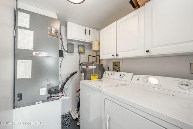 clothes washing area with heating unit, water heater, cabinets, and washing machine and clothes dryer