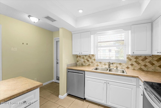 kitchen with sink, decorative backsplash, light tile patterned floors, appliances with stainless steel finishes, and white cabinetry