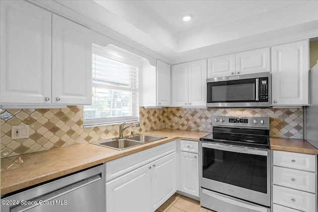 kitchen with decorative backsplash, white cabinetry, sink, and stainless steel appliances