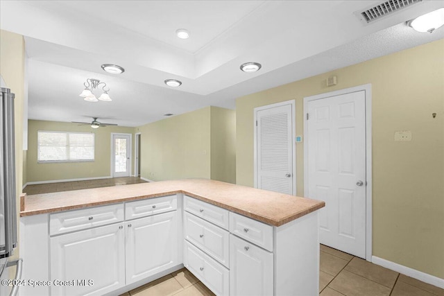 kitchen with white cabinets, light tile patterned floors, kitchen peninsula, and ceiling fan