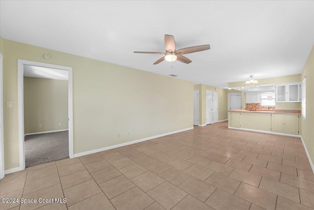 unfurnished living room featuring ceiling fan and light tile patterned flooring