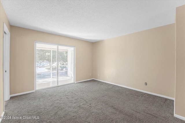 unfurnished room featuring carpet flooring and a textured ceiling