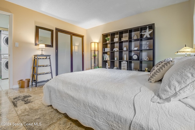 bedroom featuring a closet and stacked washer and clothes dryer