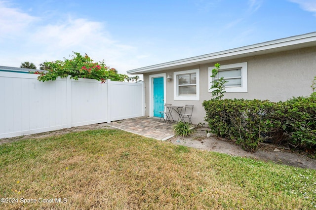 entrance to property with a lawn