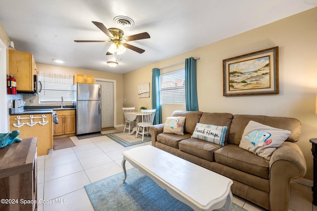 tiled living room featuring ceiling fan, plenty of natural light, and sink