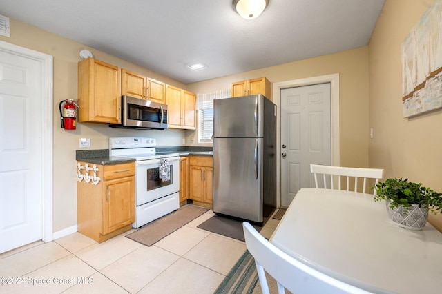 kitchen featuring light brown cabinets, light tile patterned flooring, and appliances with stainless steel finishes