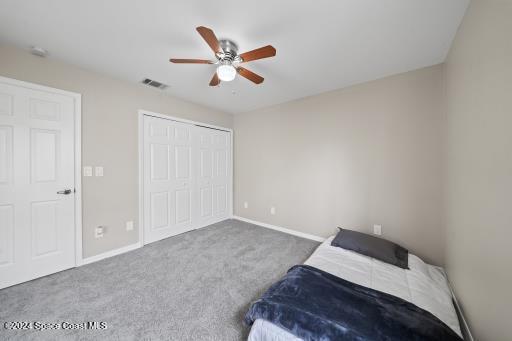 carpeted bedroom featuring a closet and ceiling fan