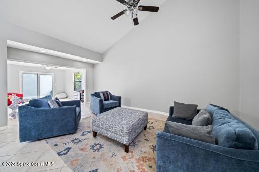 tiled living room featuring high vaulted ceiling and ceiling fan