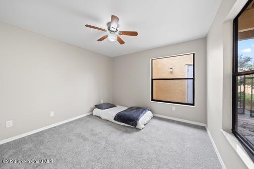 unfurnished bedroom featuring light colored carpet and ceiling fan