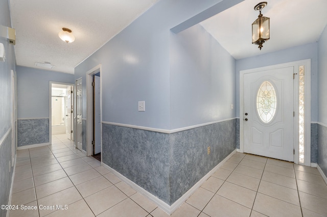 tiled entryway with a textured ceiling