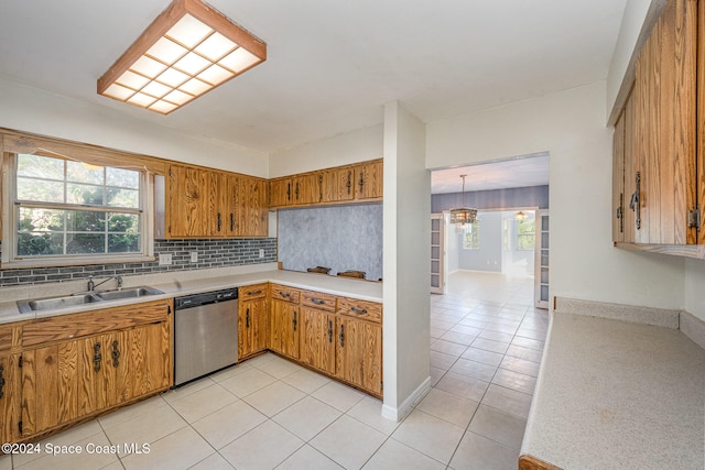 kitchen featuring decorative backsplash, stainless steel dishwasher, a wealth of natural light, and sink