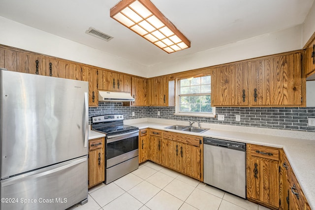 kitchen with light tile patterned floors, backsplash, stainless steel appliances, and sink