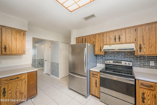 kitchen with decorative backsplash, appliances with stainless steel finishes, and light tile patterned floors