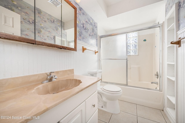 full bathroom with tile patterned floors, vanity, toilet, and bath / shower combo with glass door