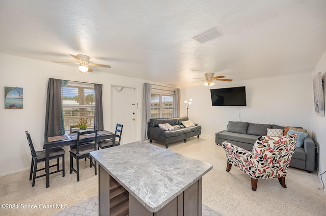 living room featuring ceiling fan and a healthy amount of sunlight