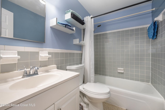 full bathroom featuring shower / bath combination with curtain, vanity, toilet, and tile walls