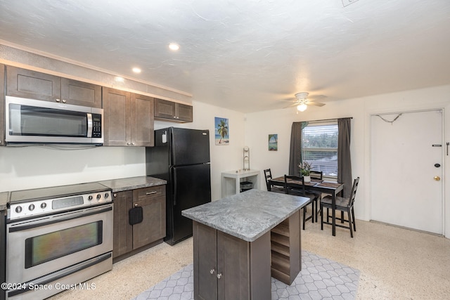 kitchen featuring dark brown cabinetry, ceiling fan, a center island, stainless steel appliances, and a textured ceiling