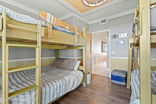 bedroom featuring wooden walls and dark wood-type flooring