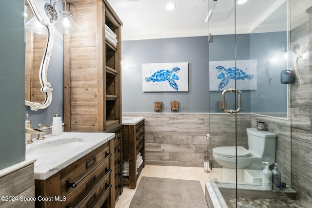 bathroom with vanity, toilet, ornamental molding, tile walls, and walk in shower