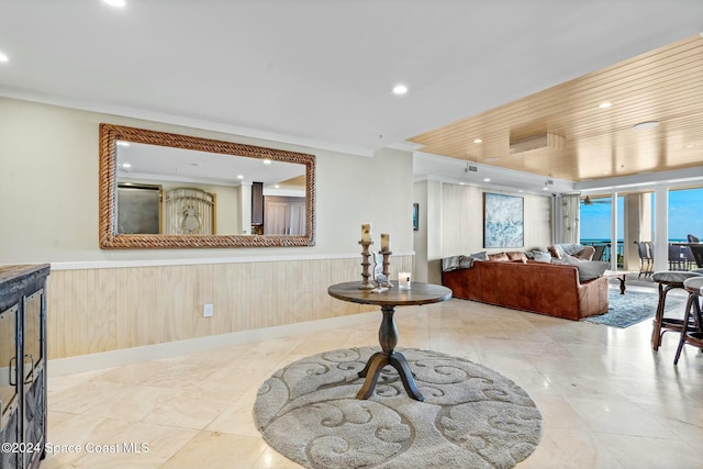 interior space with crown molding and wood walls