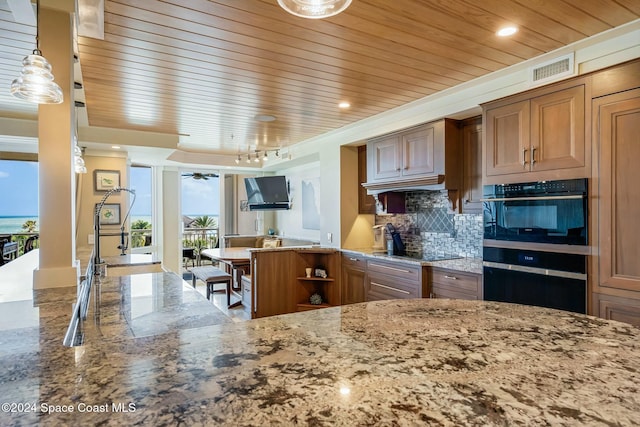 kitchen featuring light stone countertops, decorative backsplash, decorative light fixtures, and black appliances