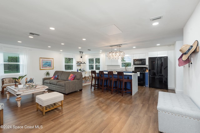 living room featuring a chandelier, light wood-type flooring, and plenty of natural light